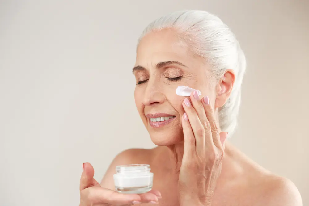 Woman applying Anti-Ageing Creams to her face as part of a daily skincare routine.