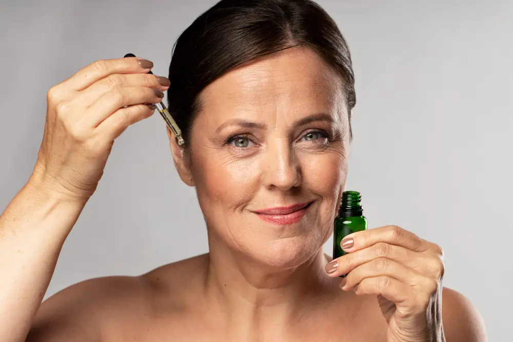Woman applying Anti-Ageing Serum with a dropper to her face for an Anti-Ageing Serum Buying Guide.