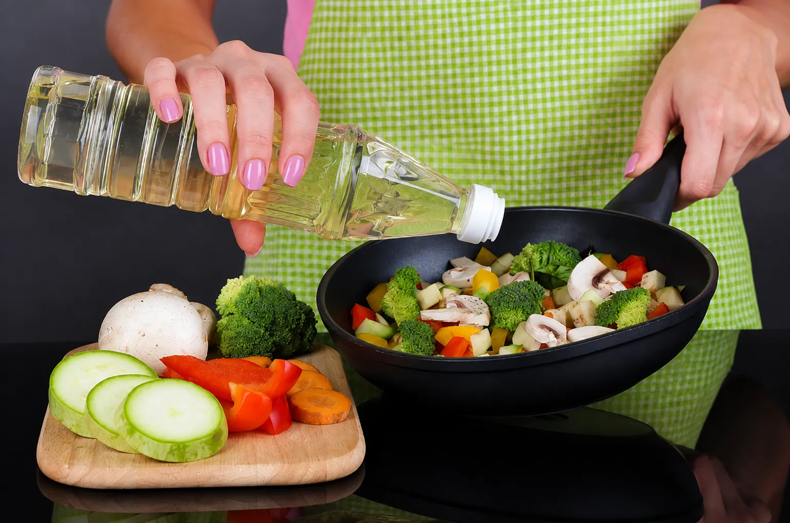 Cooking filling low-calorie vegetables including broccoli, mushrooms, zucchini and peppers in a pan for a healthy, satisfying meal.